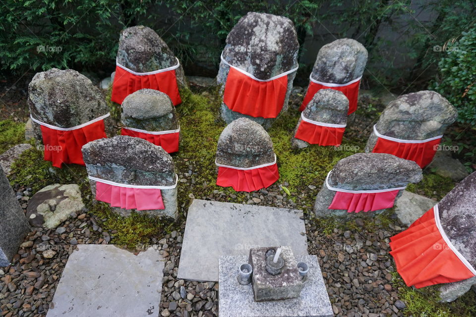 Stone statues representing the souls of the departed wearing red aprons