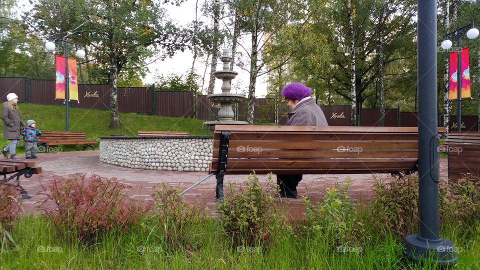 It's a bitter sweet picture. You may see an old lady who's seating by the fountain and some young people are entering into the park. 