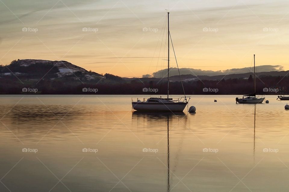 Sailing on lake Windermere. Yachts moored under the sunset