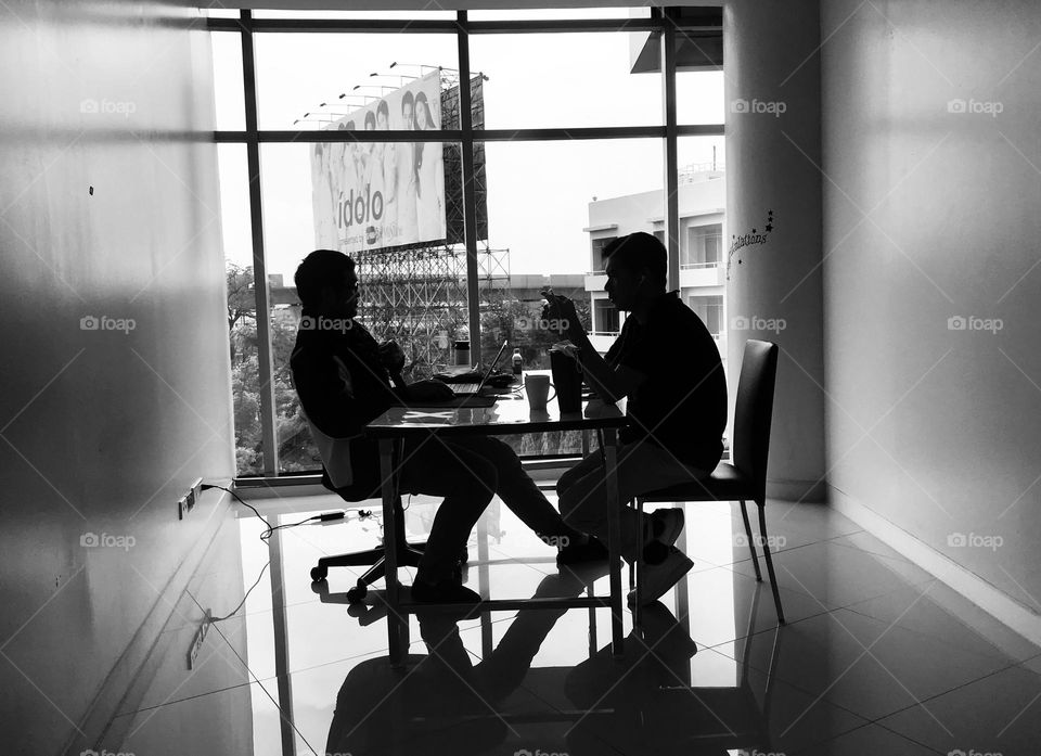 Two people in room near window 