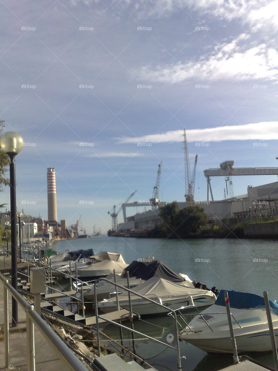 italian port, boats and landscape with chimney. shipyard
