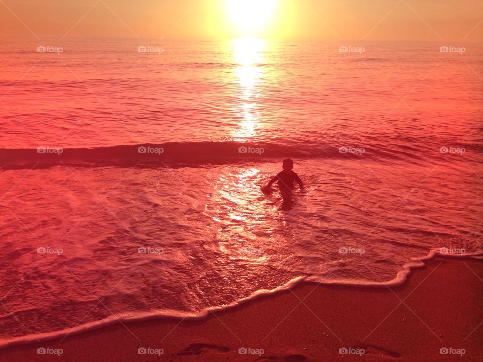 Boy in the ocean . Boy in the ocean at the golden hour.