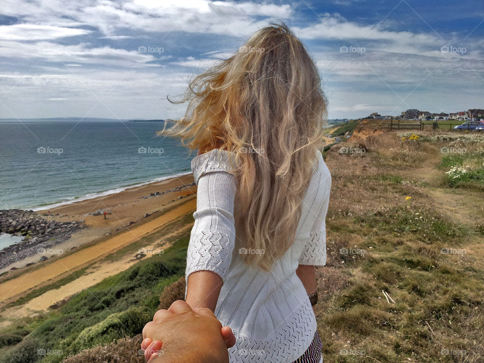 blonde girl stand onthe cliff, seascape background