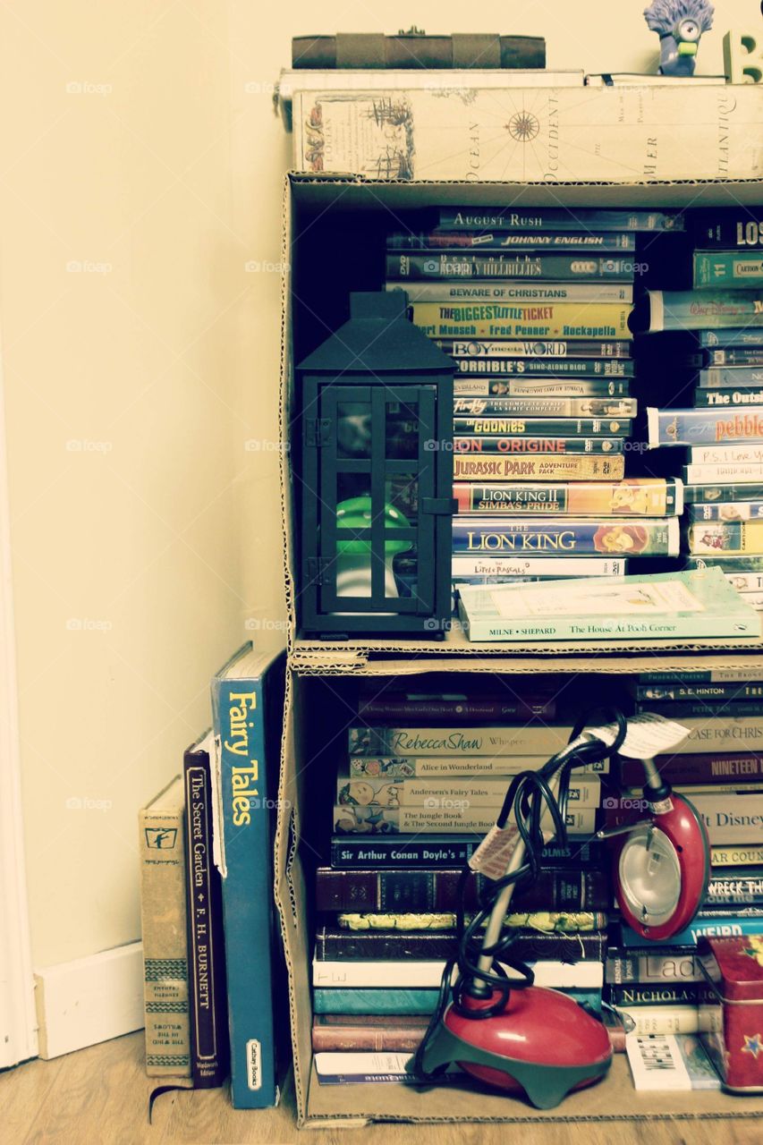 Makeshift bookshelf filled with books and movies 