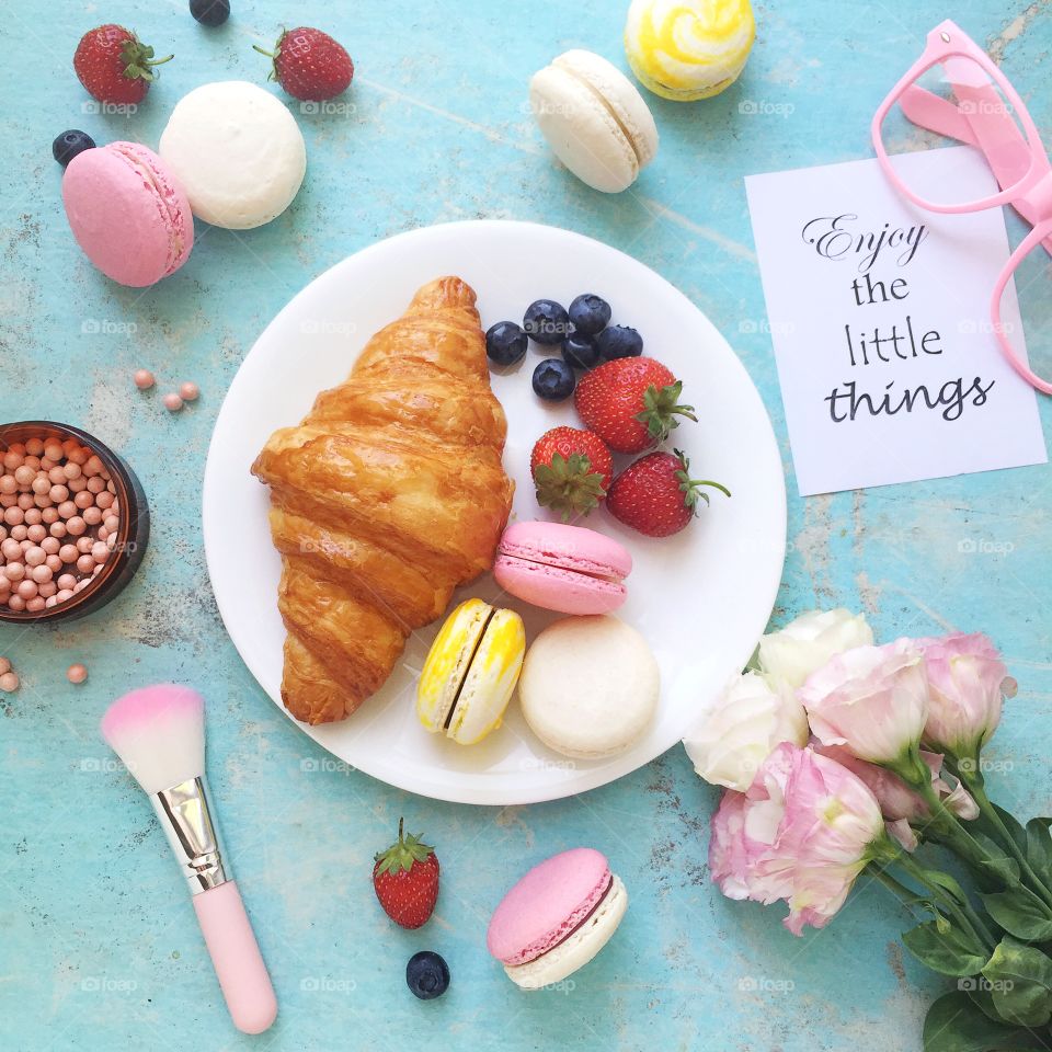 Food flat lay photo. Croissant with berries and macarons