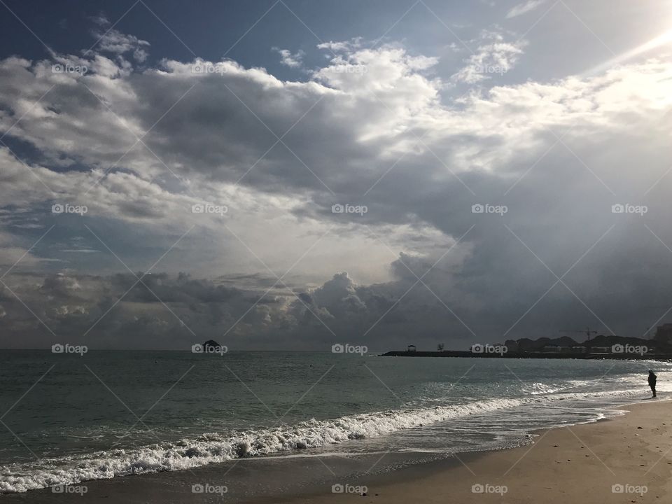 Alone on the deserted beach on a very cloudy day