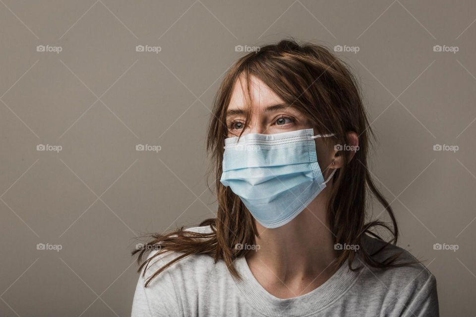 A photo of a lady putting on a nose mask