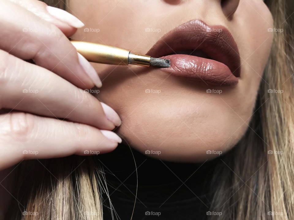 Applying liquid lipstick 