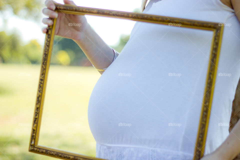 pregnant girl with frame over her tummy
