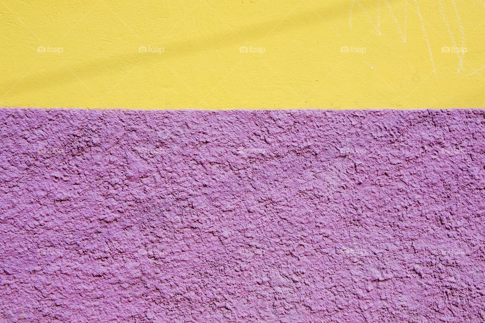 
A colorful yellow and purple exterior wall of a house in San Miguel de Allende, Mexico.