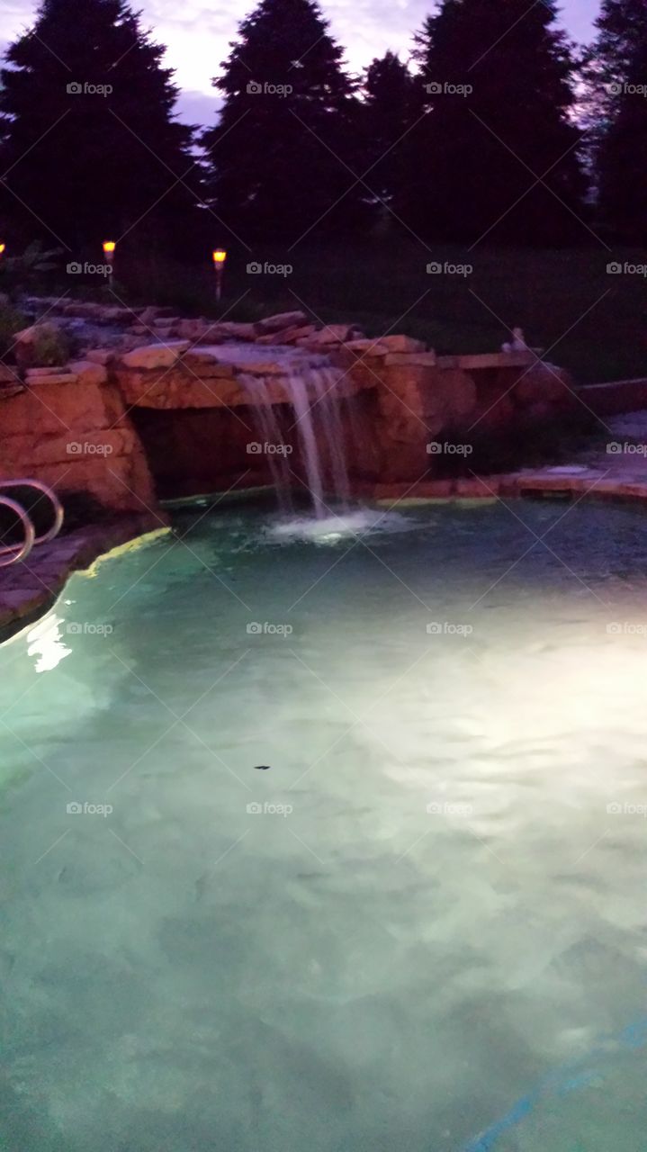 swimming pool with waterfall. night swimming
