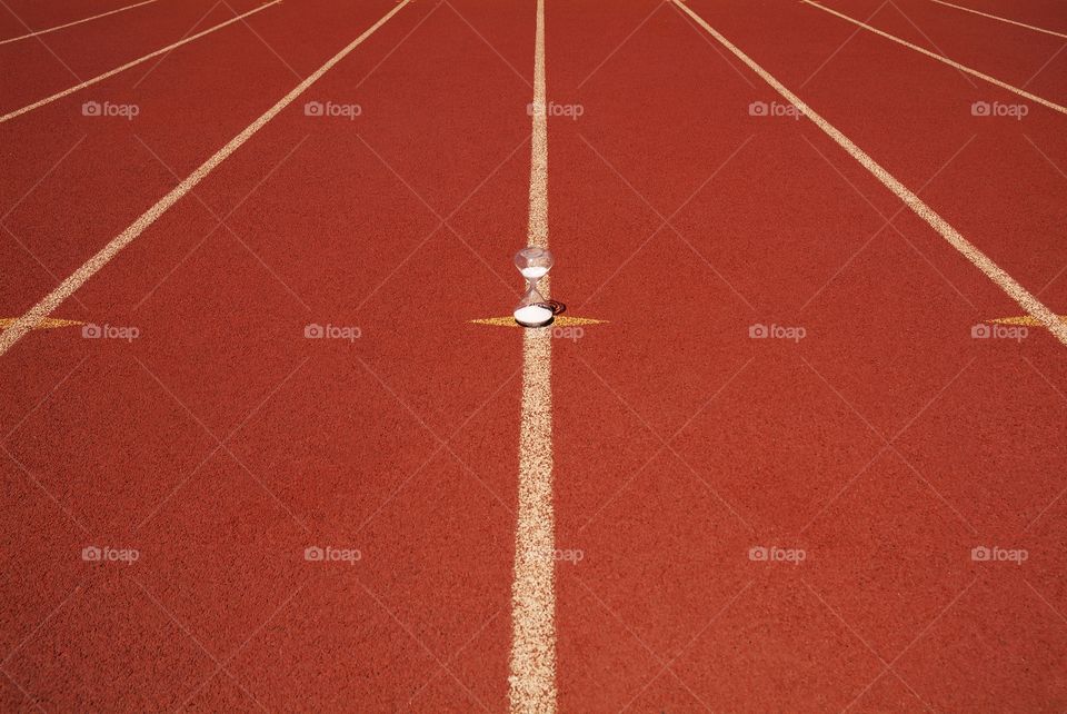 An hourglass sits in the middle of a highschool racetrack.