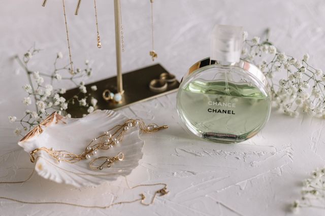 Delicate arrangements with jewelry and an enchanting Chanel perfume on a white background.