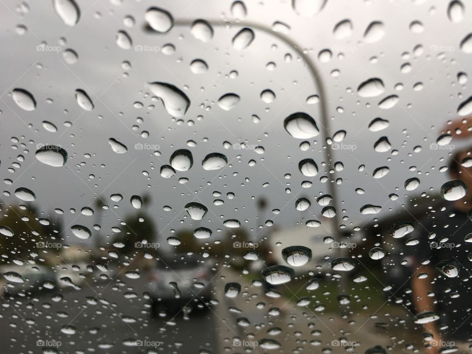 The droplets of water on the car's windshield against the grey background are good news and a happy story in the dry, hot California. After 6 months of no rain this grey story is a happy one! 