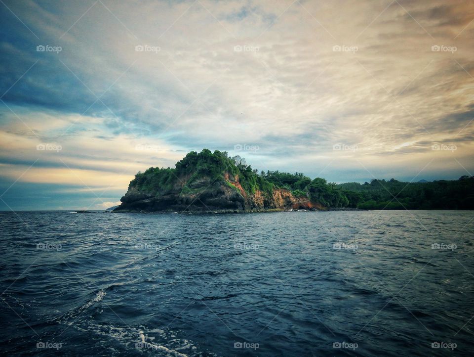 Natural scenery, the beauty of the combination of a green island, sea and cloud views in the afternoon.