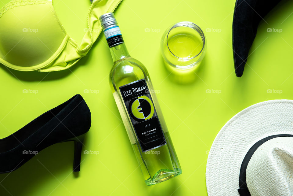 Flat lay of a bottle of Ecco Domani wine and scattered clothing items 