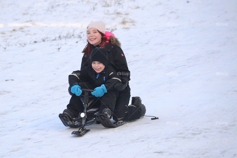 Children in their sled going down the hill