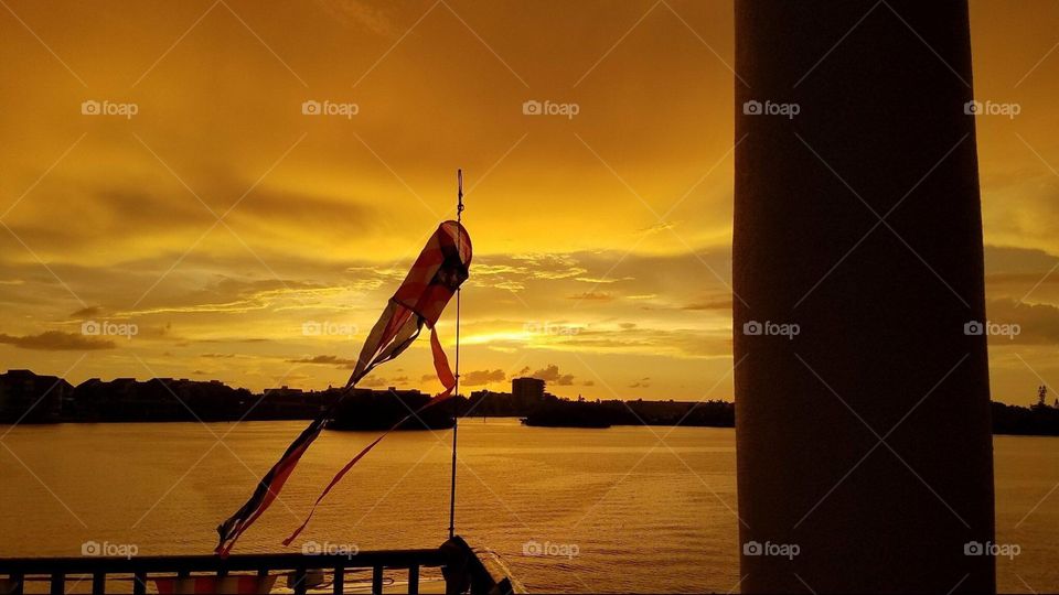 Wind sock in front of water during sunset 