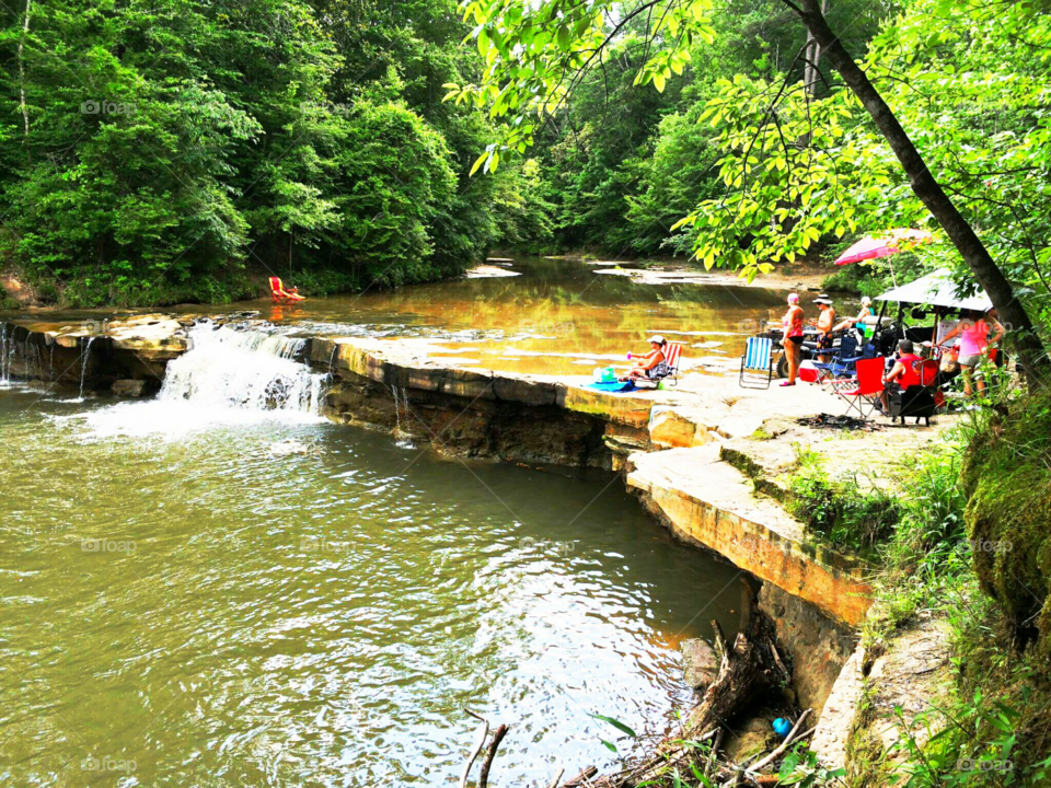 people enjoying rock ledge waterfall