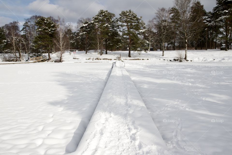 Longing for summer. Beach and jetty in snow, Sweden - Längtar efter sommar . Badplats med mycket snö. strand och brygga i Kåsjön, Partille, Sverige