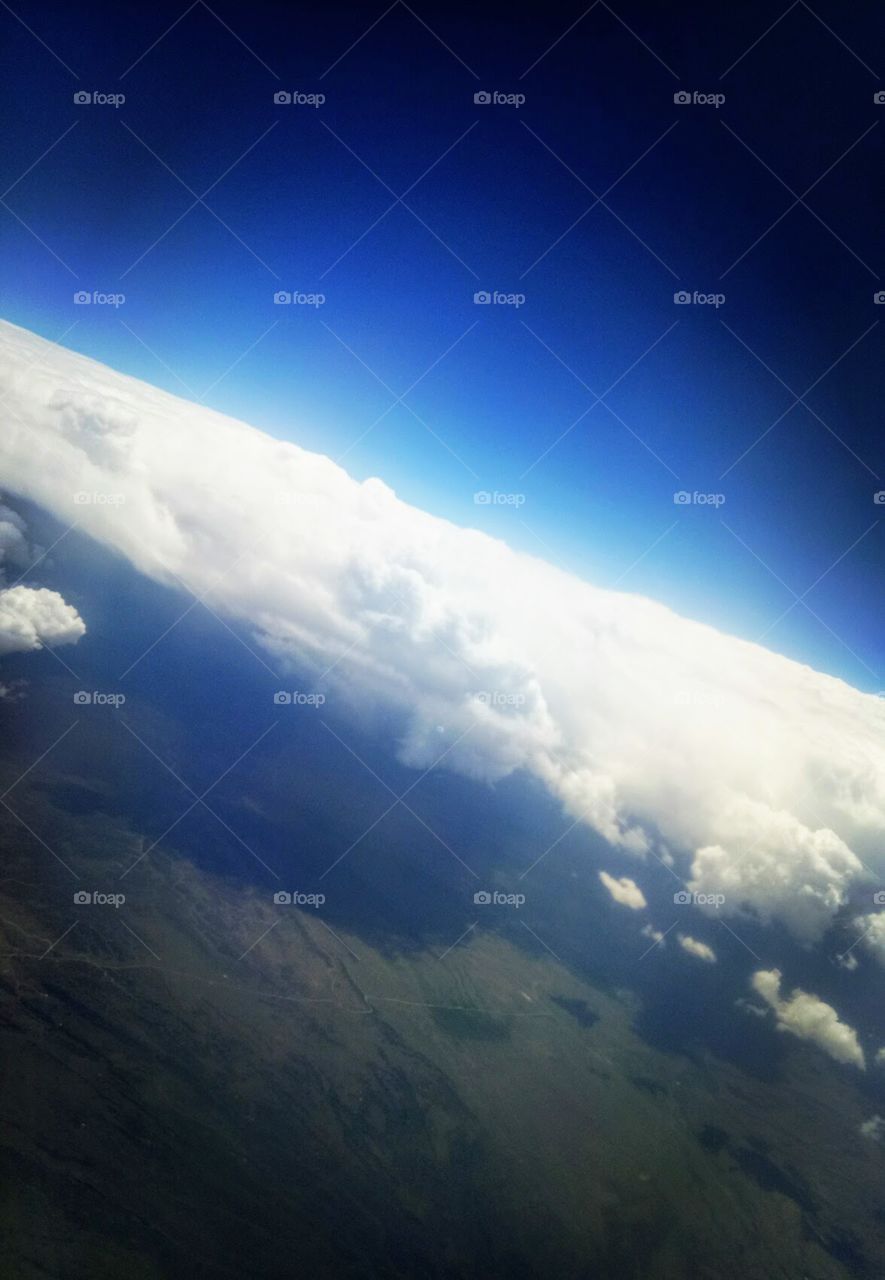 View outside the plane. Beautiful clouds. Blue sky. Mountains below. Beauty of the heaven.