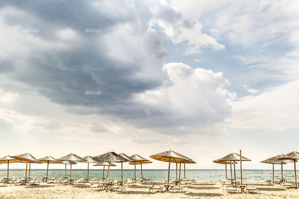 Straw Beach Umbrellas And Sunbeds On The Beach
