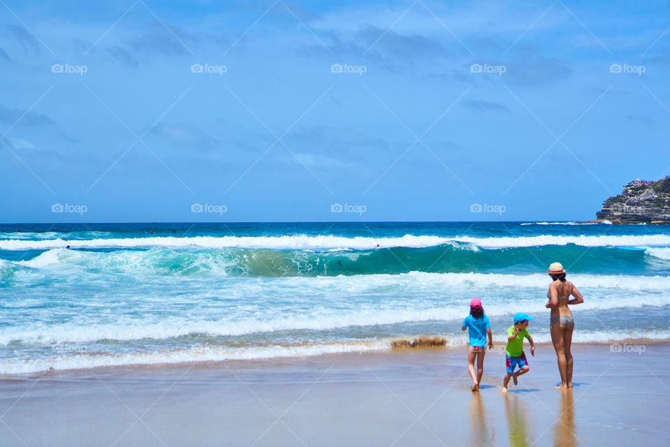A family enjoying the waves at Bondi Beach.