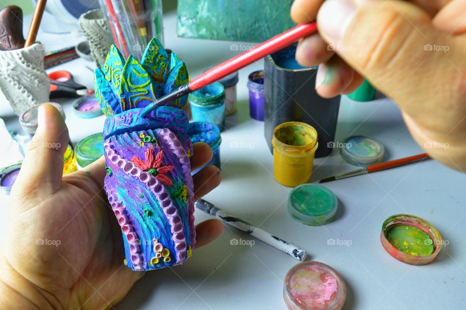 my home workshop for pouring and painting ceramic and earthenware jugs. The photo shows a jug being painted with acrylic.