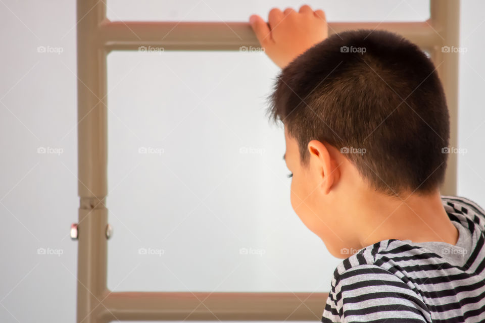 Portrait of Asian boys are climbing the ladder in the playground.