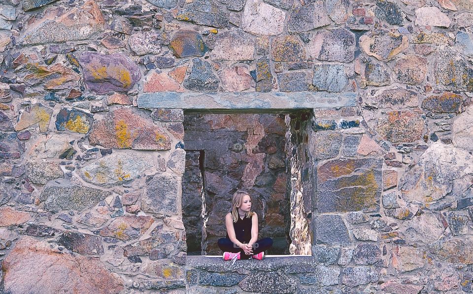 Girl sitting . Girl sitting in a window of old ruins