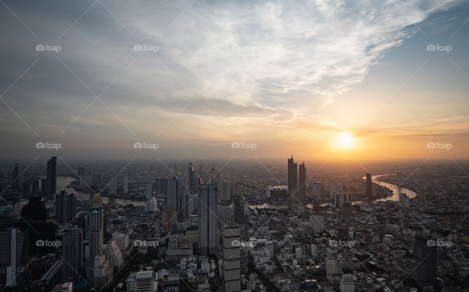 Beautiful sunset scene over skyscraper in the capital city , Bangkok Thailand roof top Mahanakorn Building 