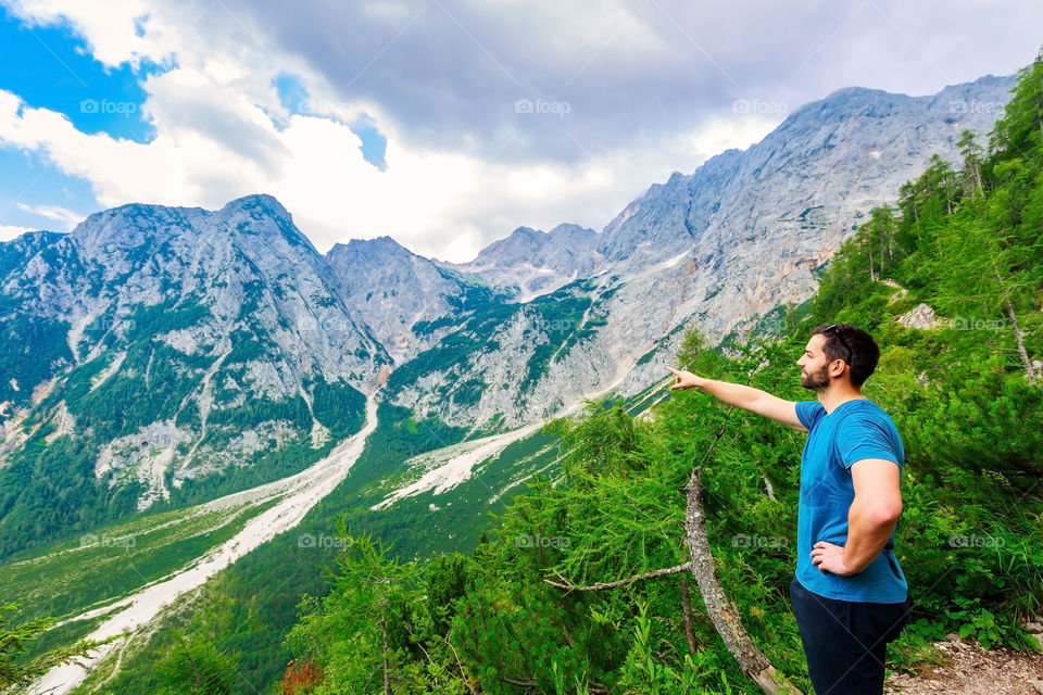 Mid adult man pointing towards mountain