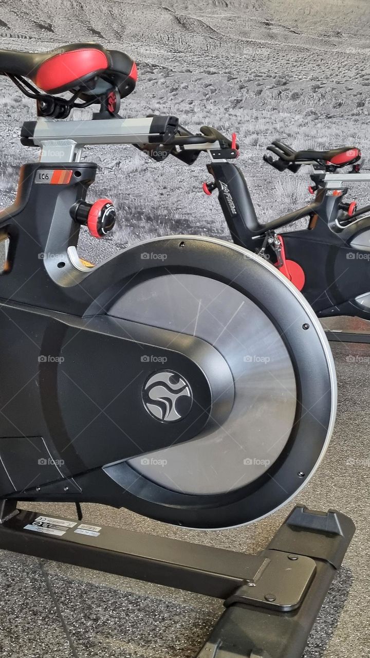 the wheel of a spinning bicycle inside a gym studio.