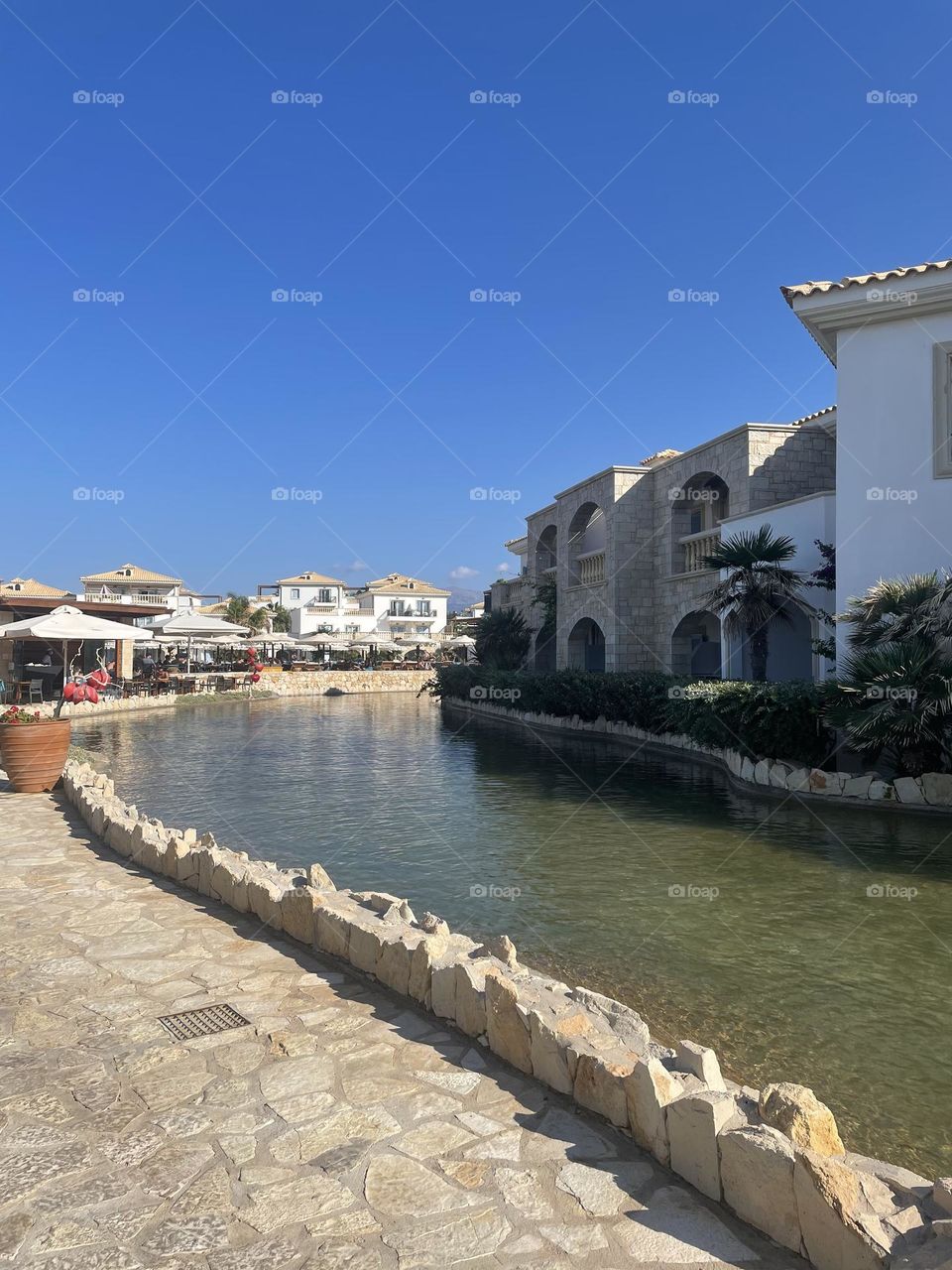Water runs gently through the grounds of a Greek beach hotel on a sunny day, September 2021.