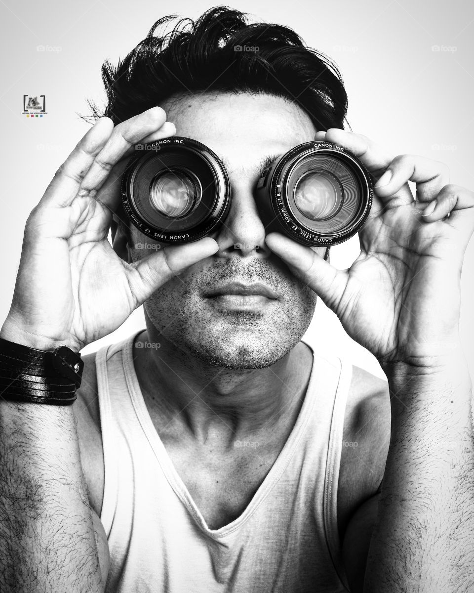 Man holding camera lens over the eyes