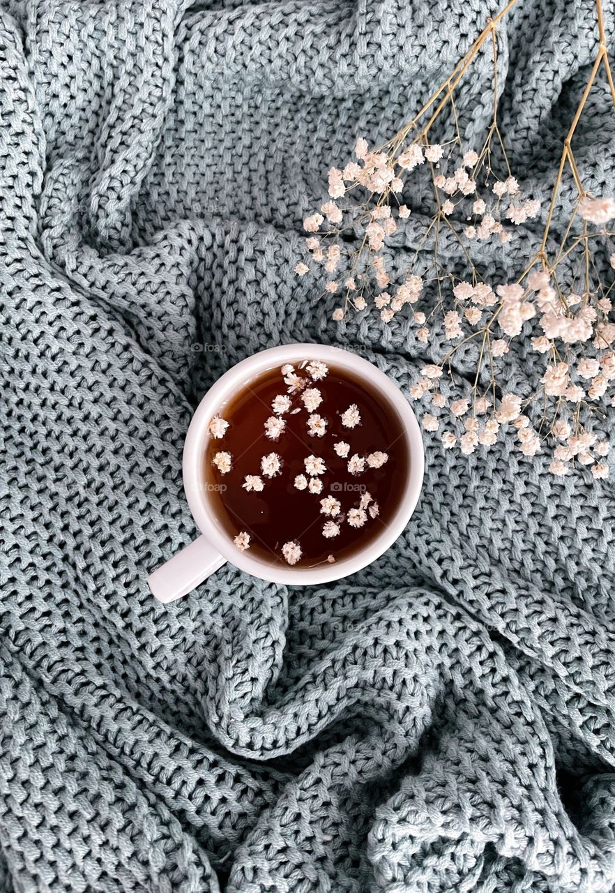 a cup of tea with white flowers
