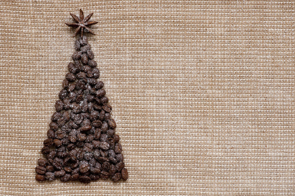Christmas tree made of coffee beans on sack background