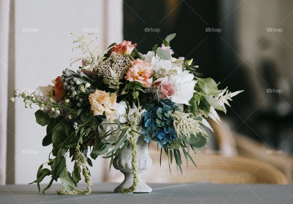 Bouquet of beautiful flowers in a vase standing on table, no people.