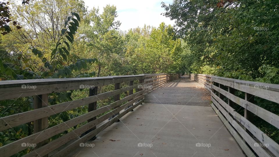 a bridge that facilitates a bike trail over a stream