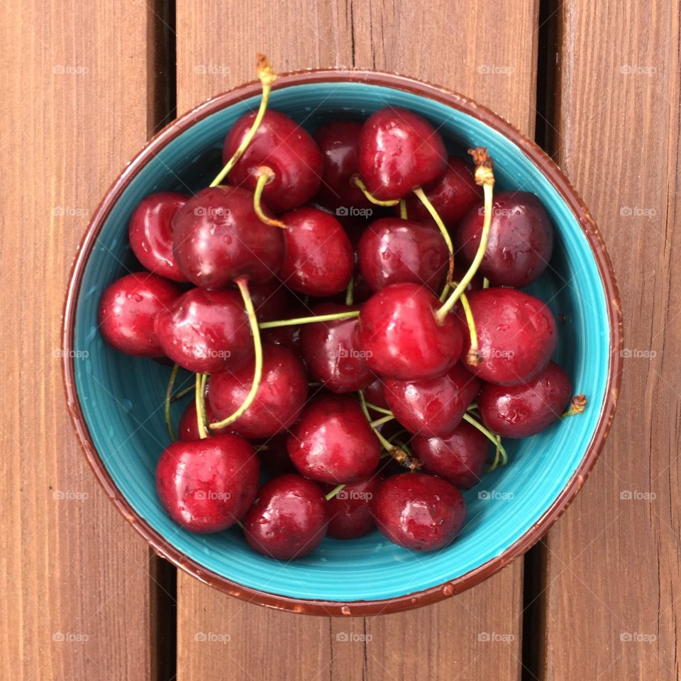 Red cherries in a turquoise bowl