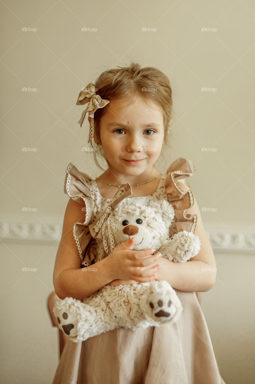 Vintage portrait of a beautiful little girl with teddy bear 