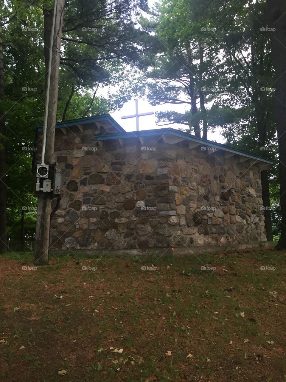 Building made of rocks with a cross en the roof