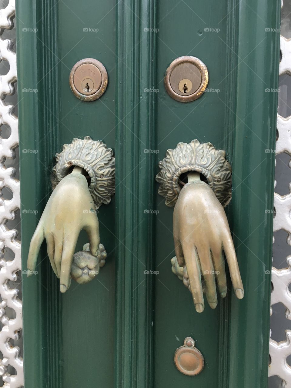 Two thin women’s hands as door bells