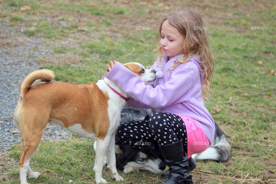 Girl with dogs on grassy field