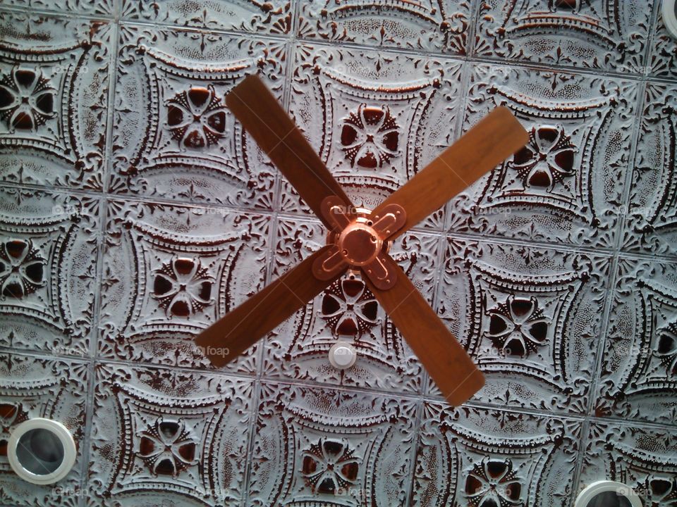 Copper Fan. Copper fan on a tin tiled ceiling...