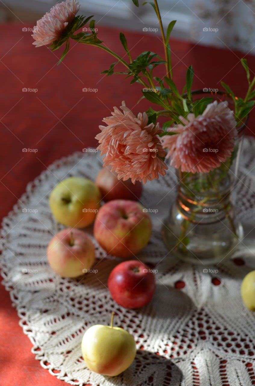 Autumn still life with apples and flowers.