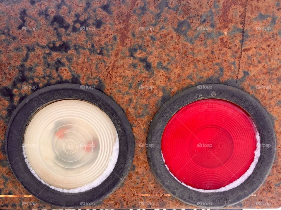 Closeup detail of a white taillight and a red taillight in rusted metal