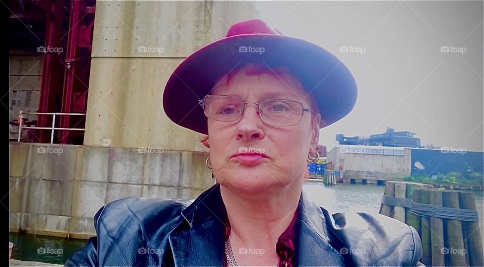 I, „Petra Schiller“ a.k.a. „Maxine Firefox“ a.k.a. „Maximiliane Feuerfuchs“ am standing in the parking lot beneath the „Pulaski Bridge“ at „Newtown Creek“ in LIC, Queens on an overcast Fall afternoon in 2022. Hypnotic Productions