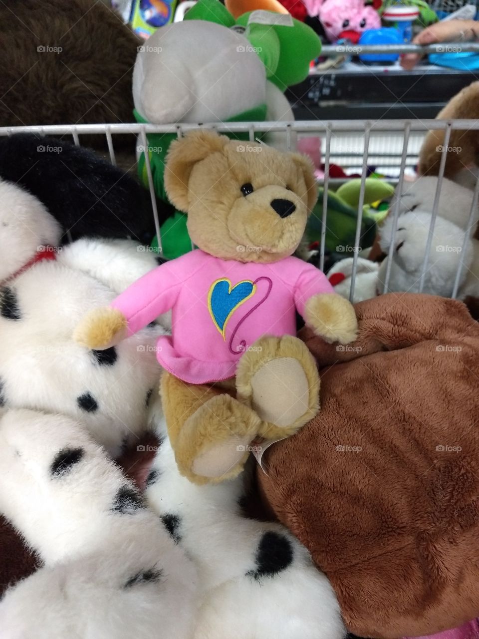 a cute bear in a pile at a thrift store