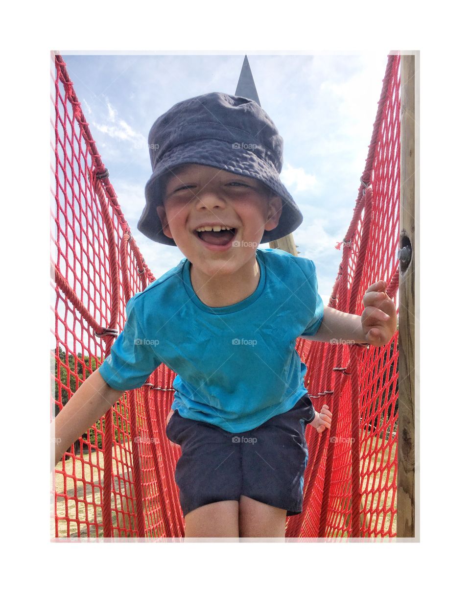 Small boy on bridge over river
